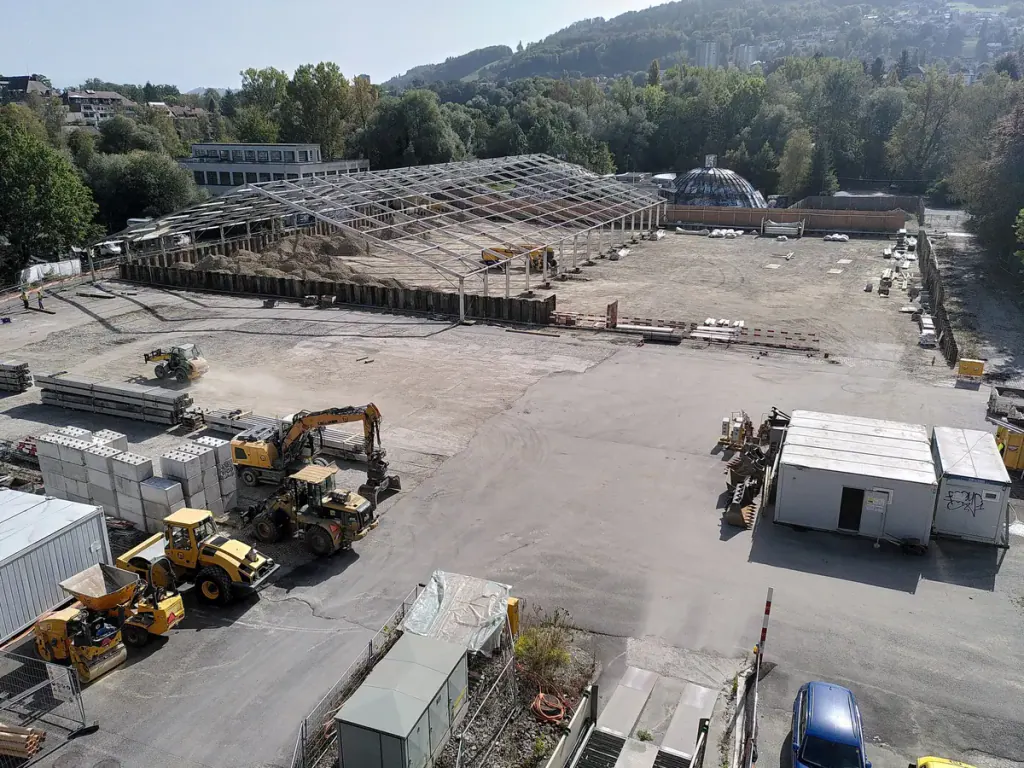 Levelled ground, site cabins and machinery on the former gasworks site in Bern after its soil remediation