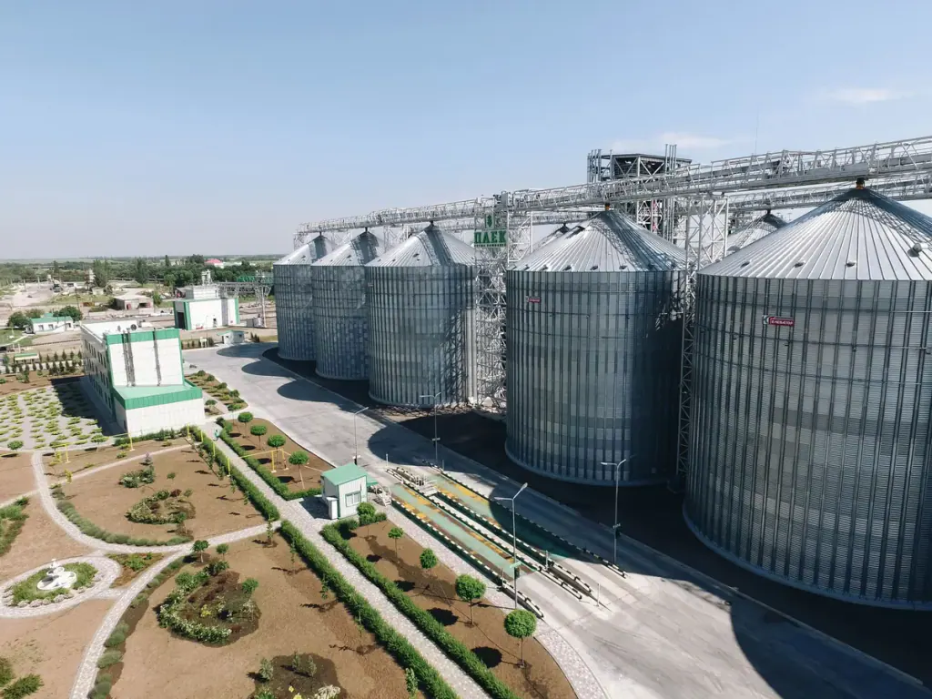 Drone view of a row of steel grain silos with the elevator's loading pit and weighbridge